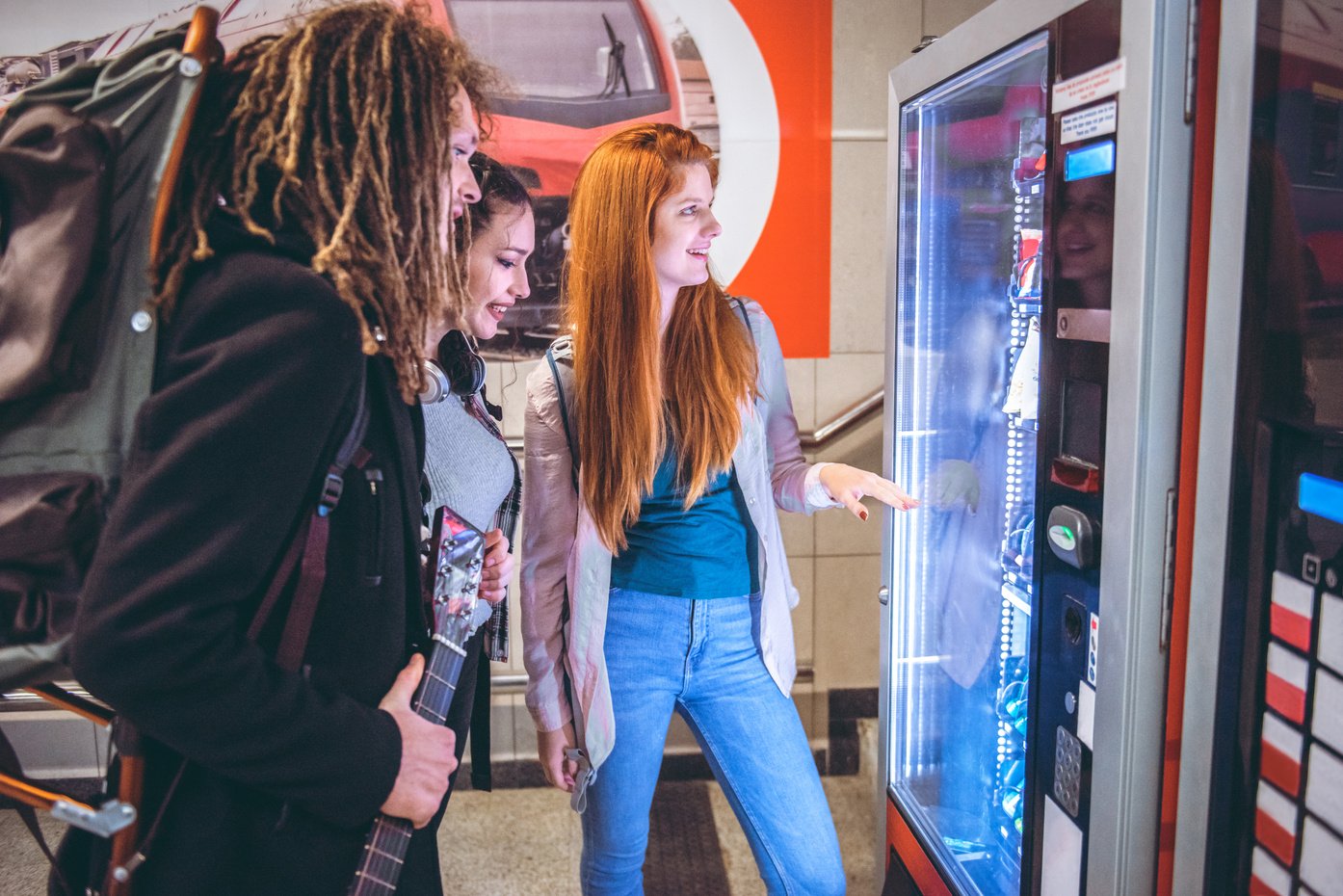 young travelers buy coffee at a vending machine